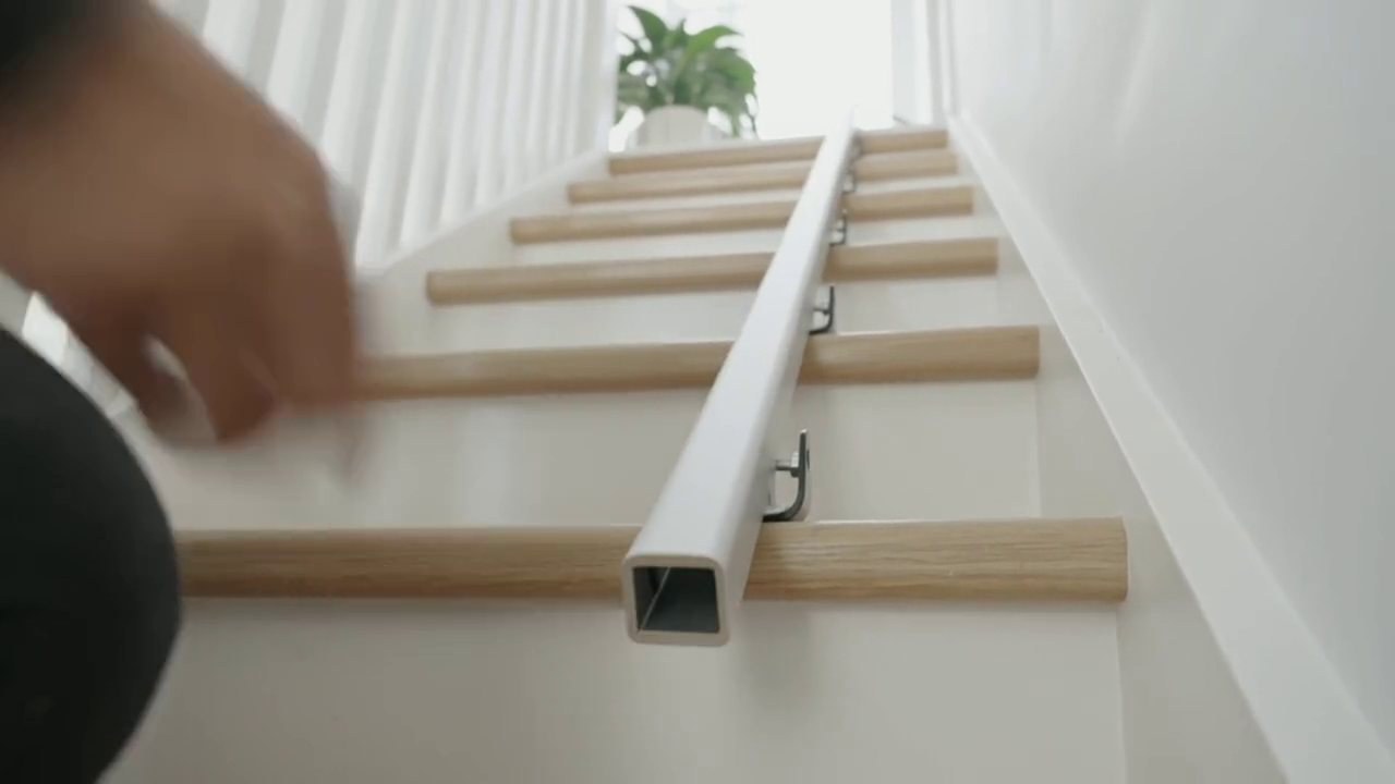 Installer fitting a stairlift rail to the stair treads